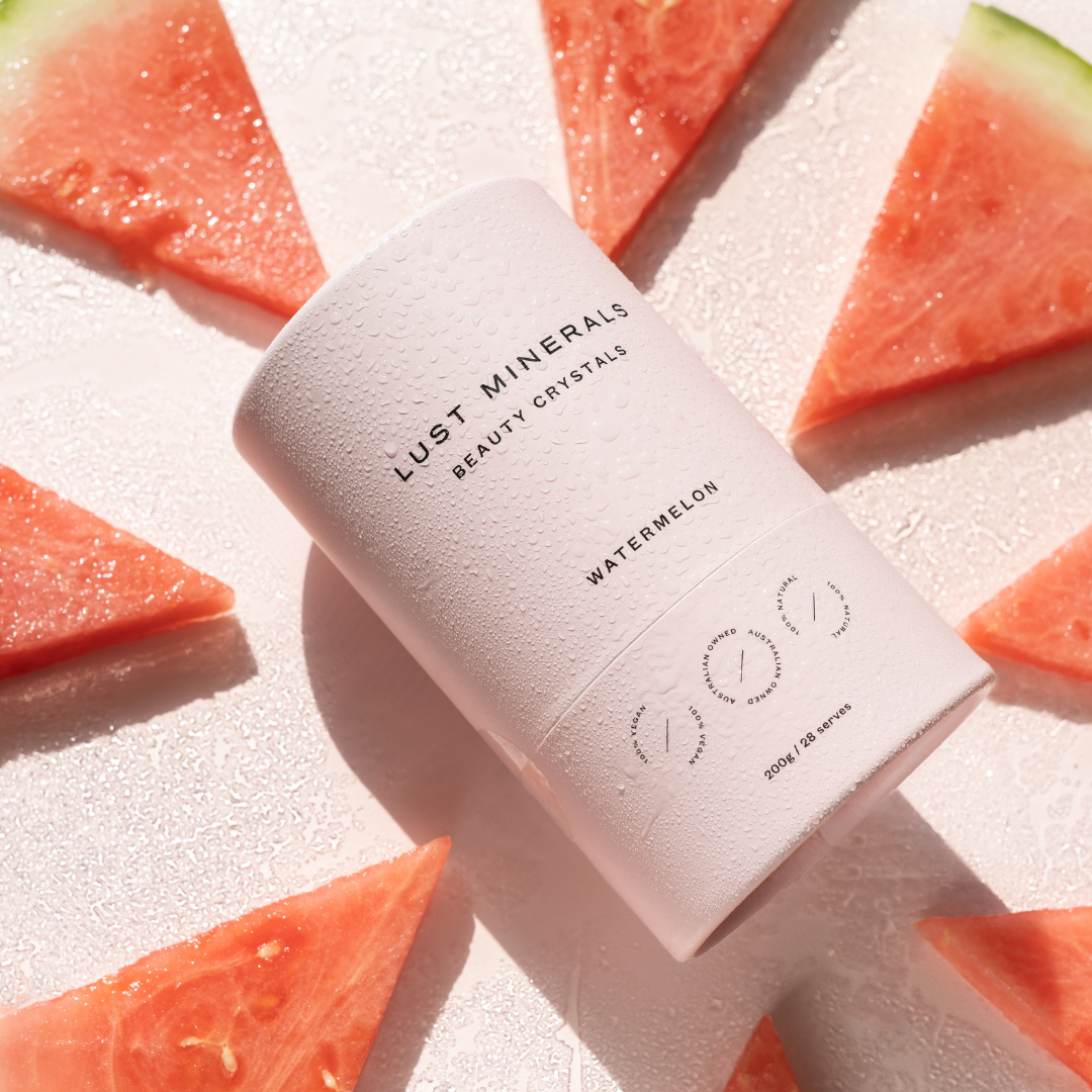 Lust Minerals beauty crystals with watermelon slices on a light background