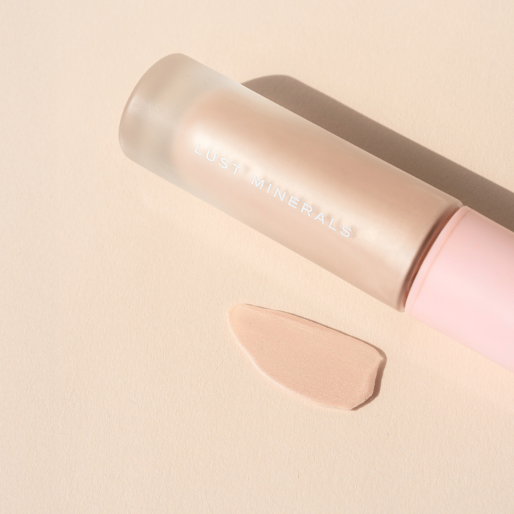 Liquid Illuminate product with a swatch on a beige background