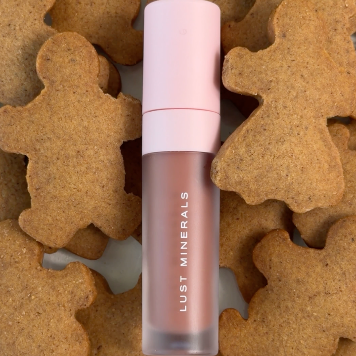 Lip gloss on a background of gingerbread cookies.