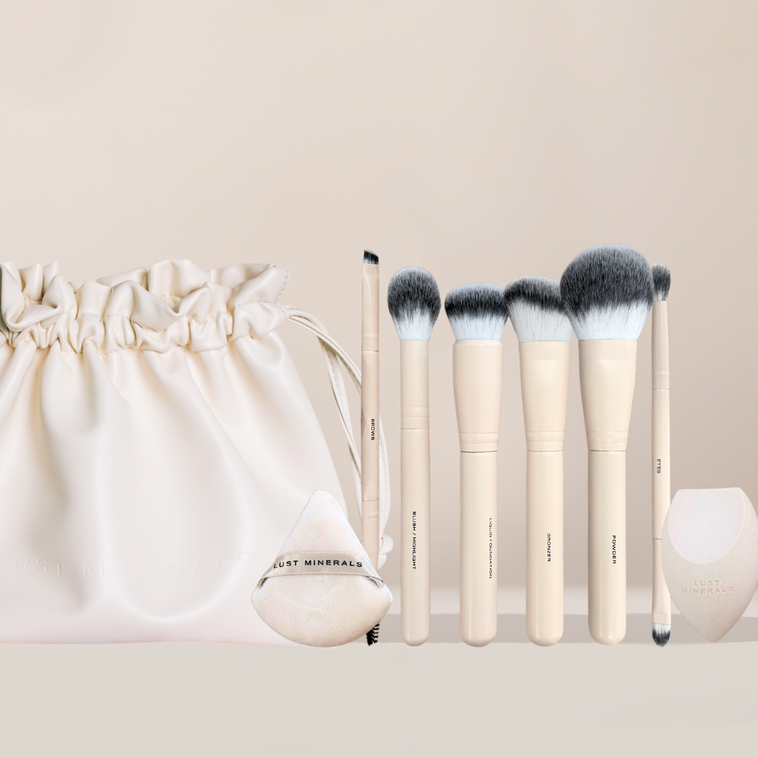 Set of makeup brushes with a cream-colored bag on a light beige background